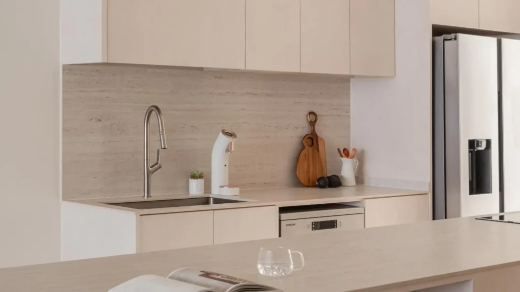 Neutral-toned kitchen with fluted island and timber bar stools designed by 6AM Spaces