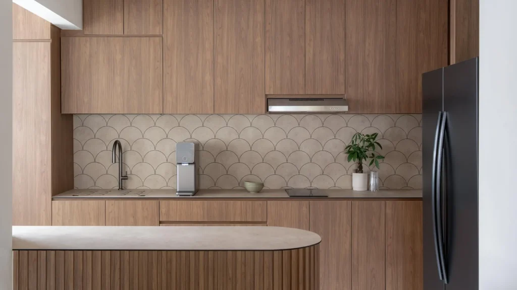Warm timber kitchen cabinetry with scallop-tile backsplash and fluted island by 6AM Spaces Singapore