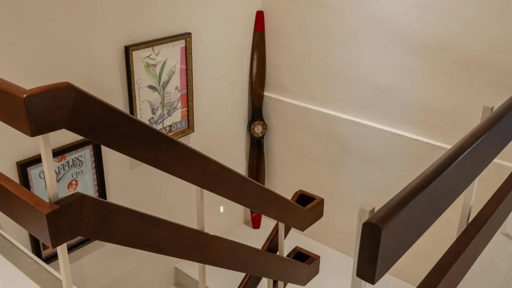 Timber staircase with accent lighting and clean handrail detail in Singapore home