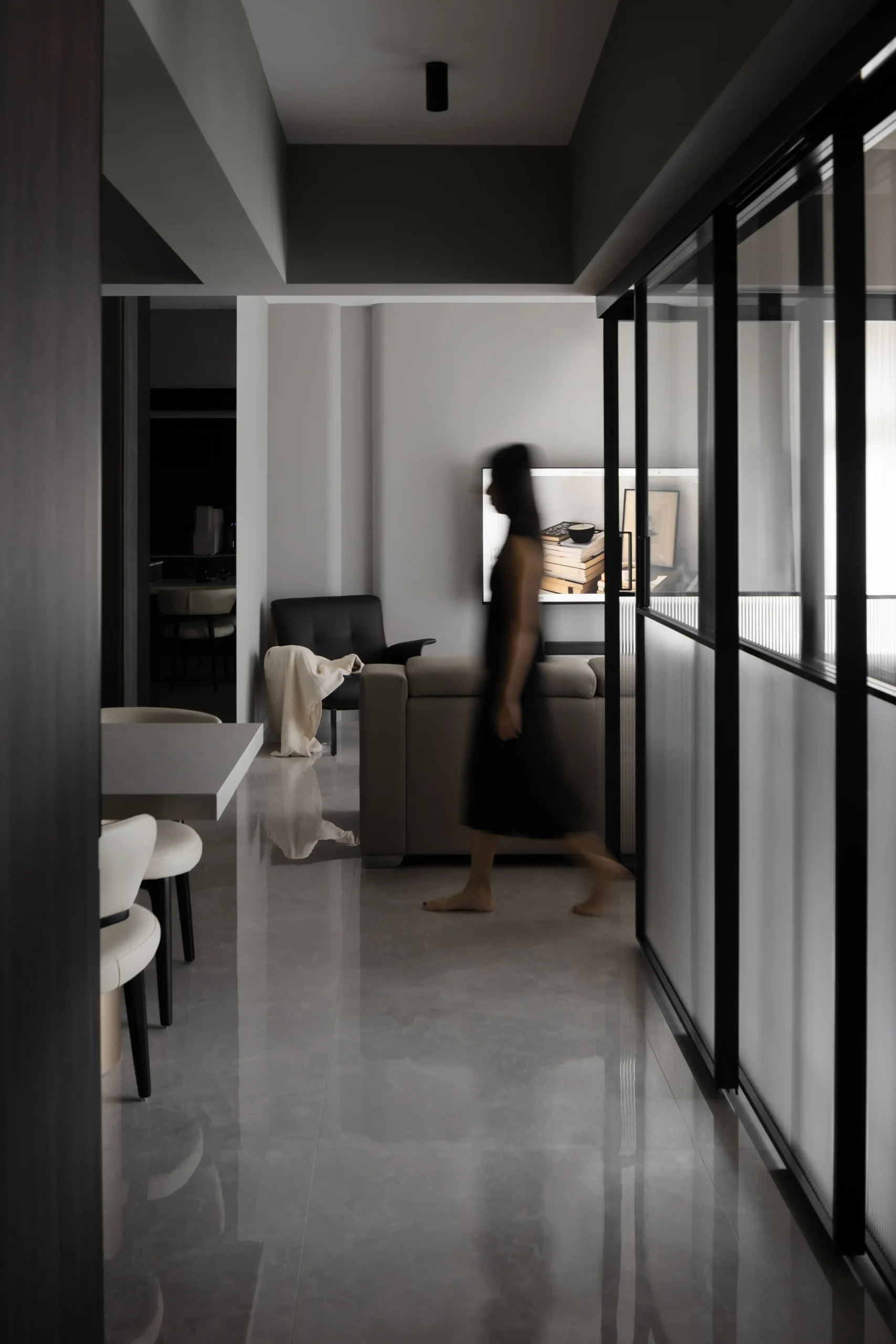 Minimalist hallway featuring glossy gray marble floor tiles, a fluted glass sliding partition wall