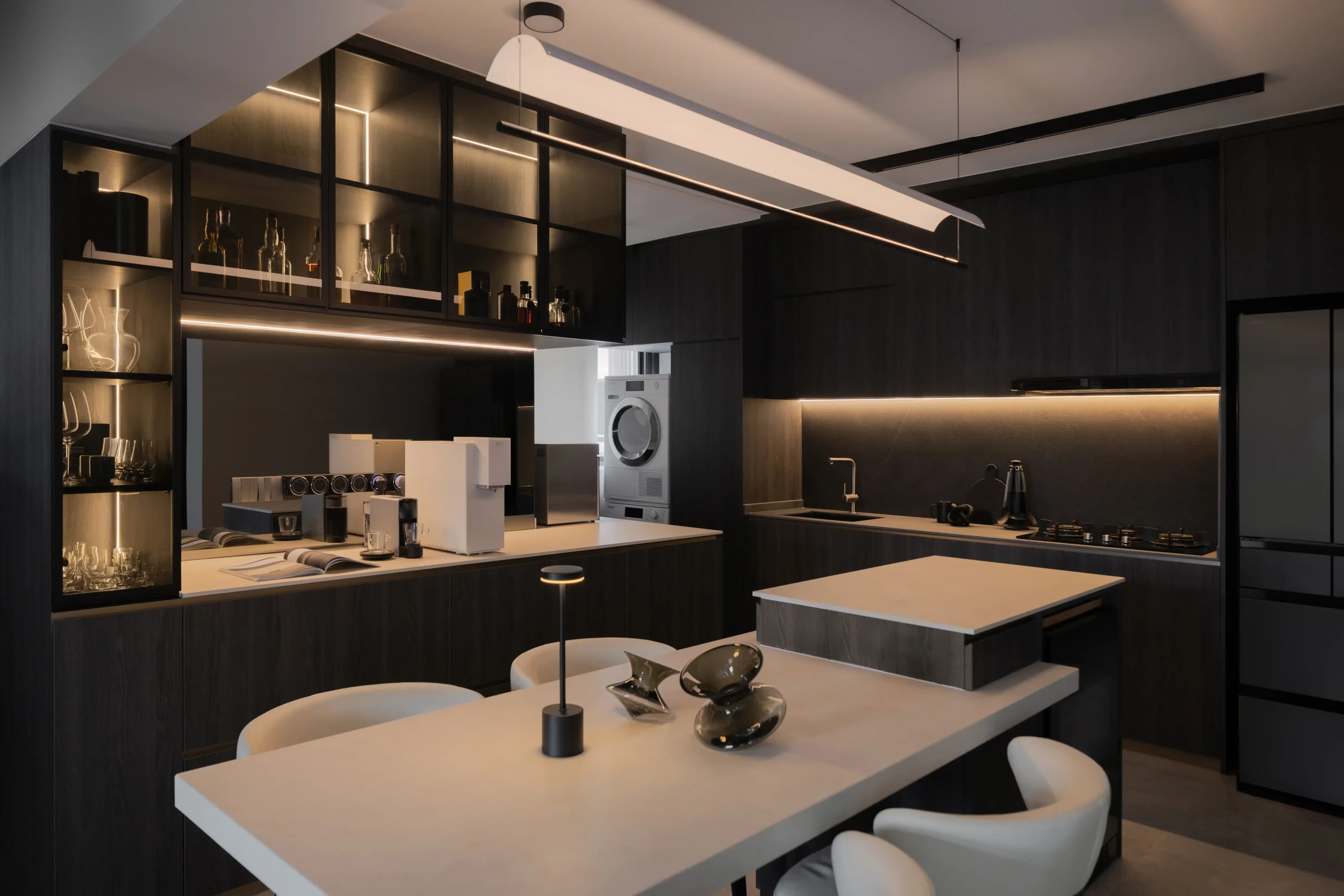 dark luxury interior kitchen and dining area illuminated by warm integrated LED strip lighting showcasing a premium glass liquor cabinet.
