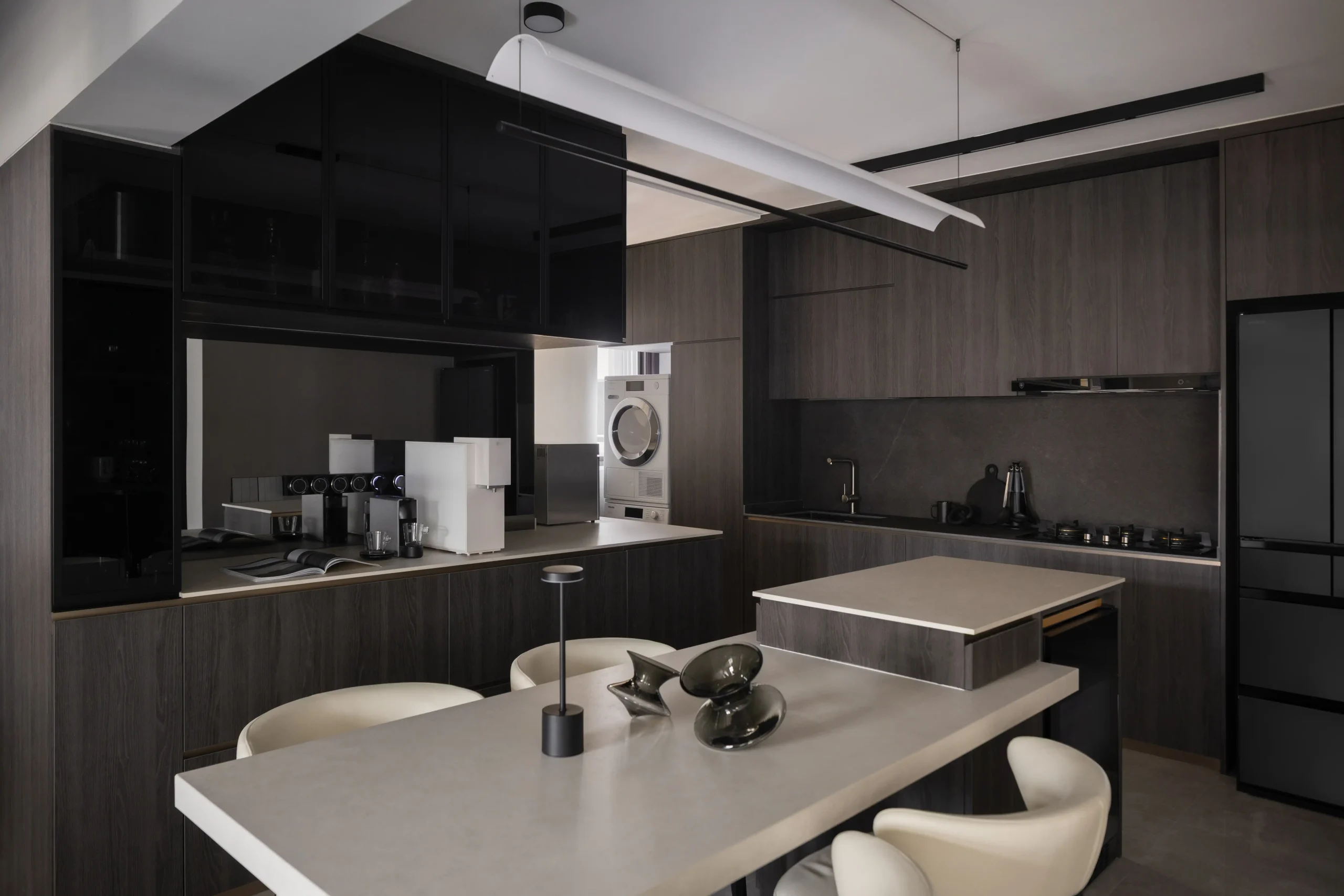 A modern dark luxury interior kitchen featuring dark wood cabinetry, an integrated white water dispenser, and sleek built-in appliances
