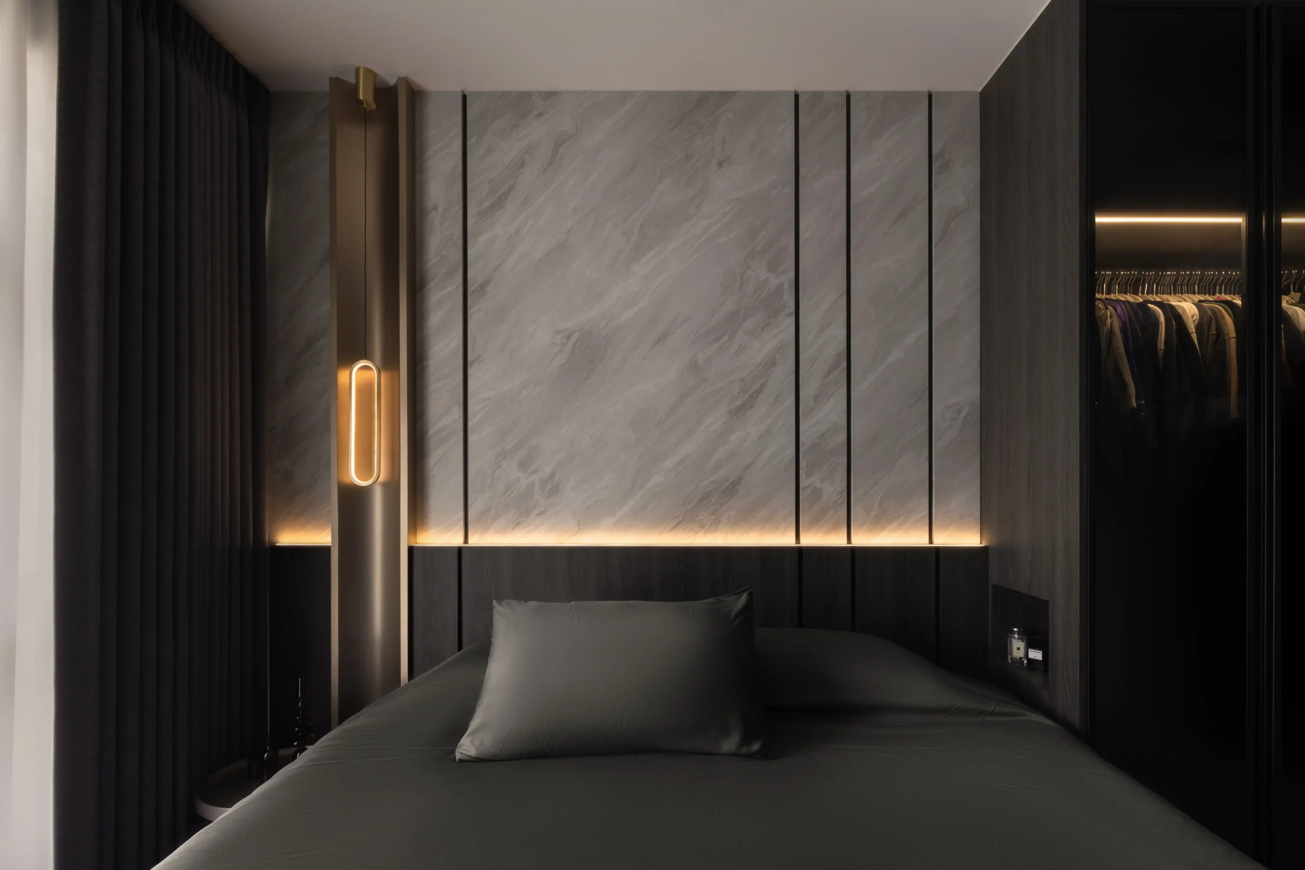 bedroom featuring a gray bed, integrated warm LED headboard lighting, and a walk-in wardrobe with glowing clothing racks.