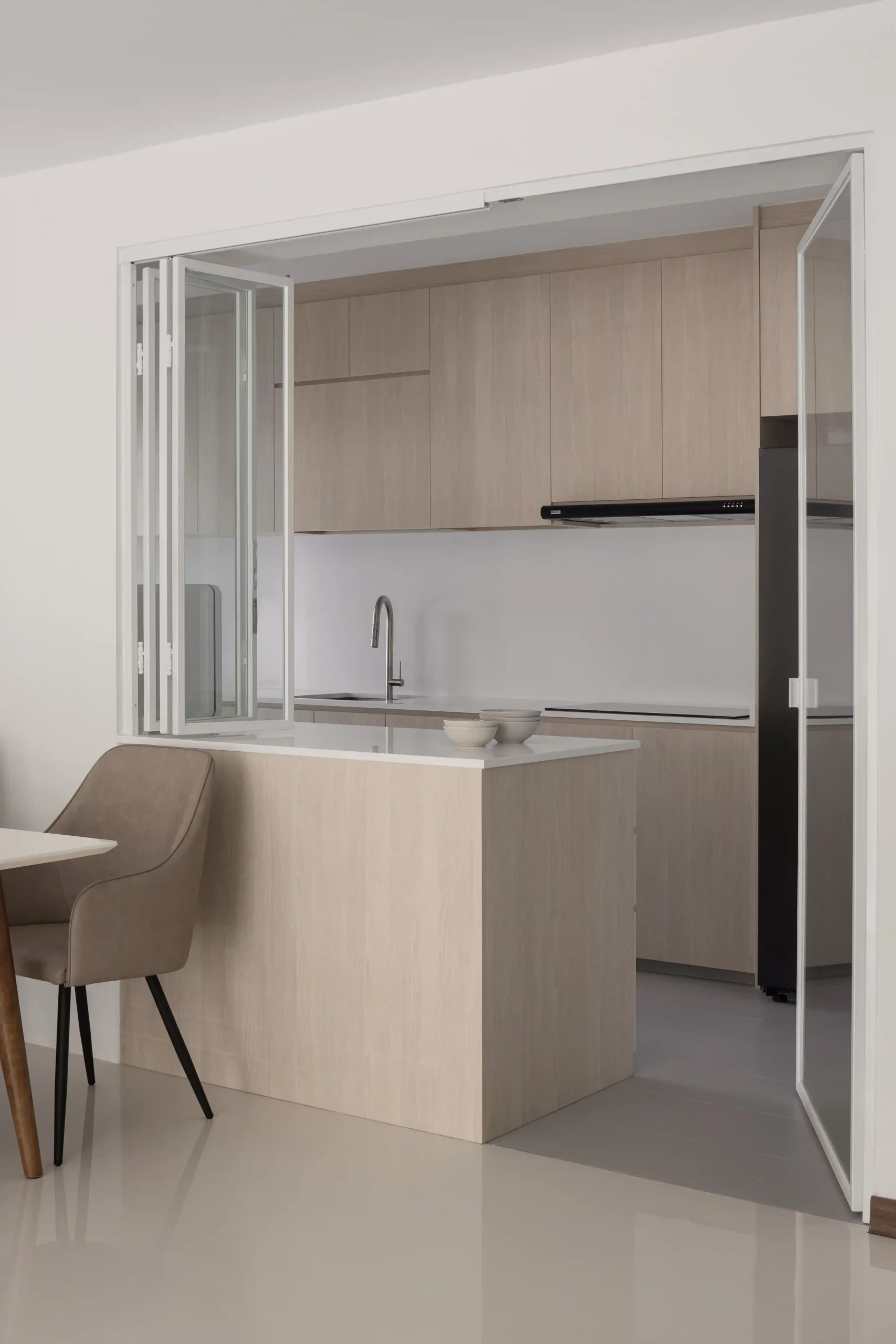 Open-concept kitchen featuring light oak cabinets and a white countertop reflecting a Japanese Scandinavian minimalist design style.