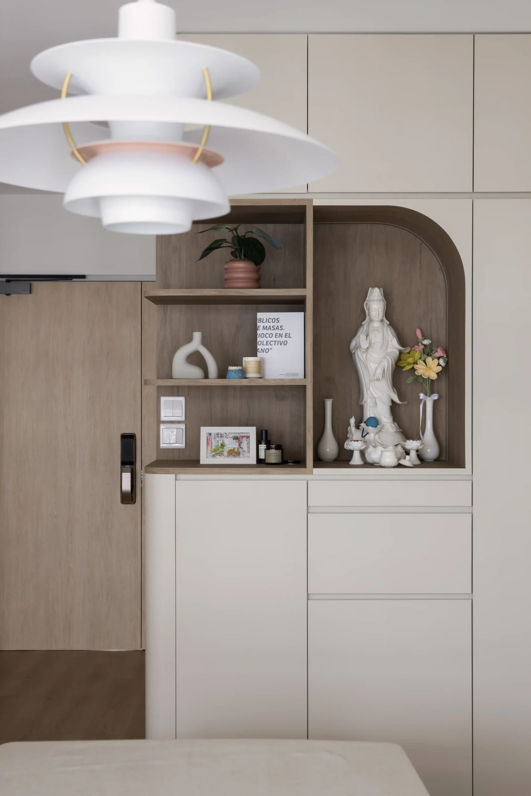 Japandi interior design entryway featuring a built-in cream cabinet with an integrated wooden altar niche and decorative shelves.