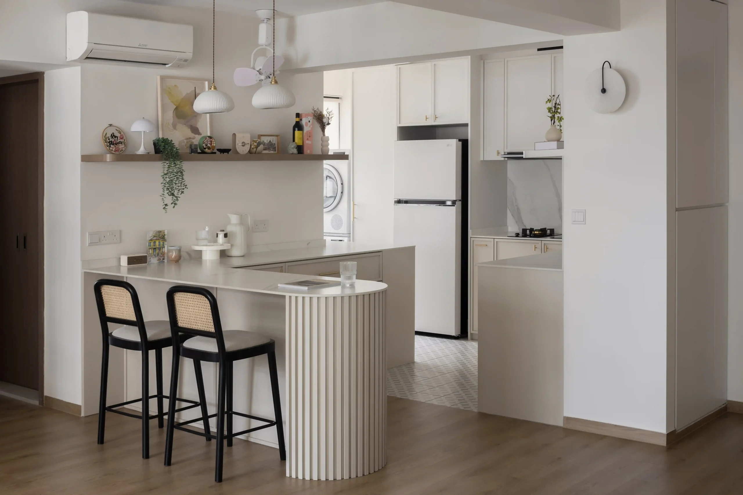 Open layout featuring a white fluted breakfast bar and warm minimalist wood shelves.
