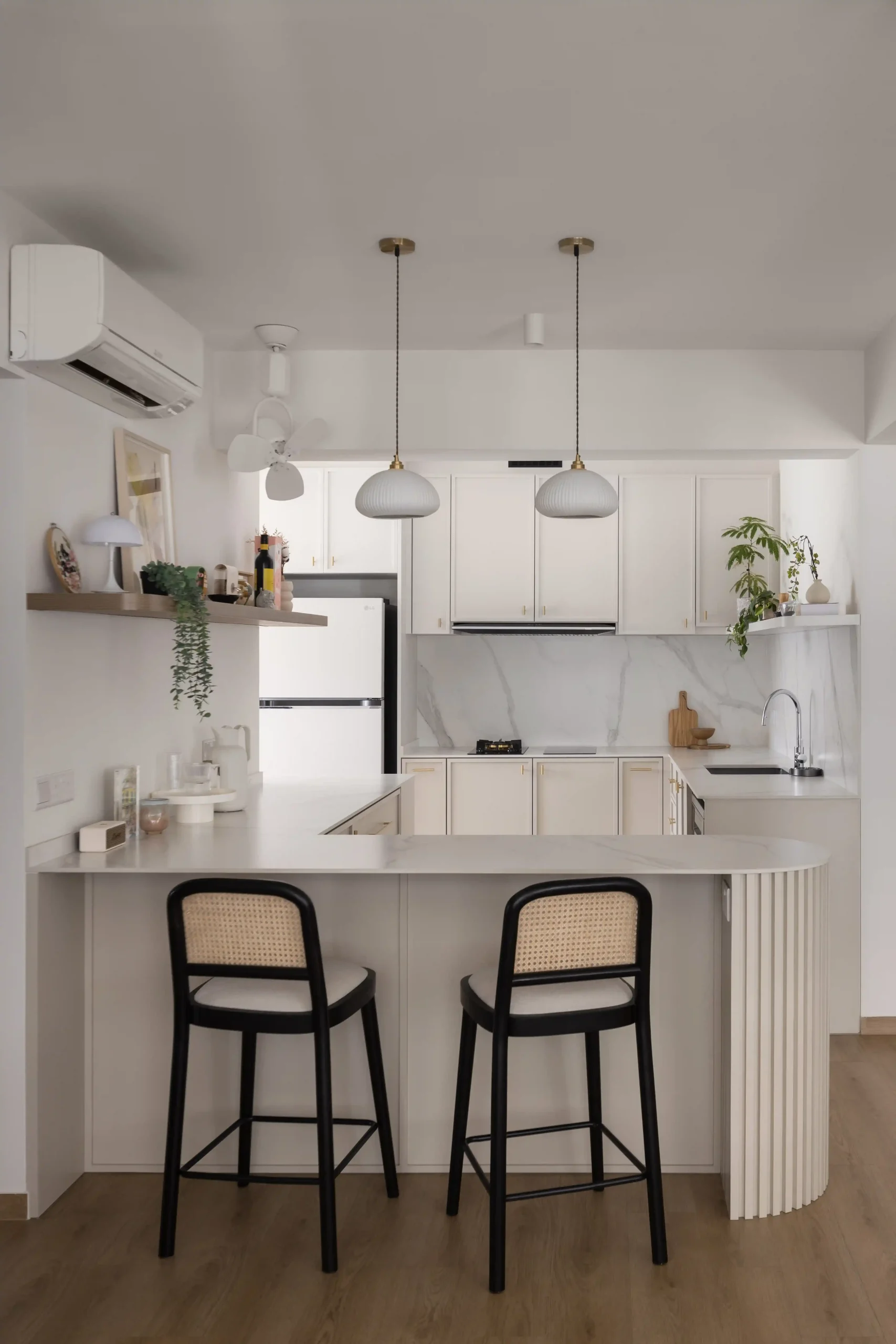 Modern condo kitchen with white cabinets in a Japandi interior.