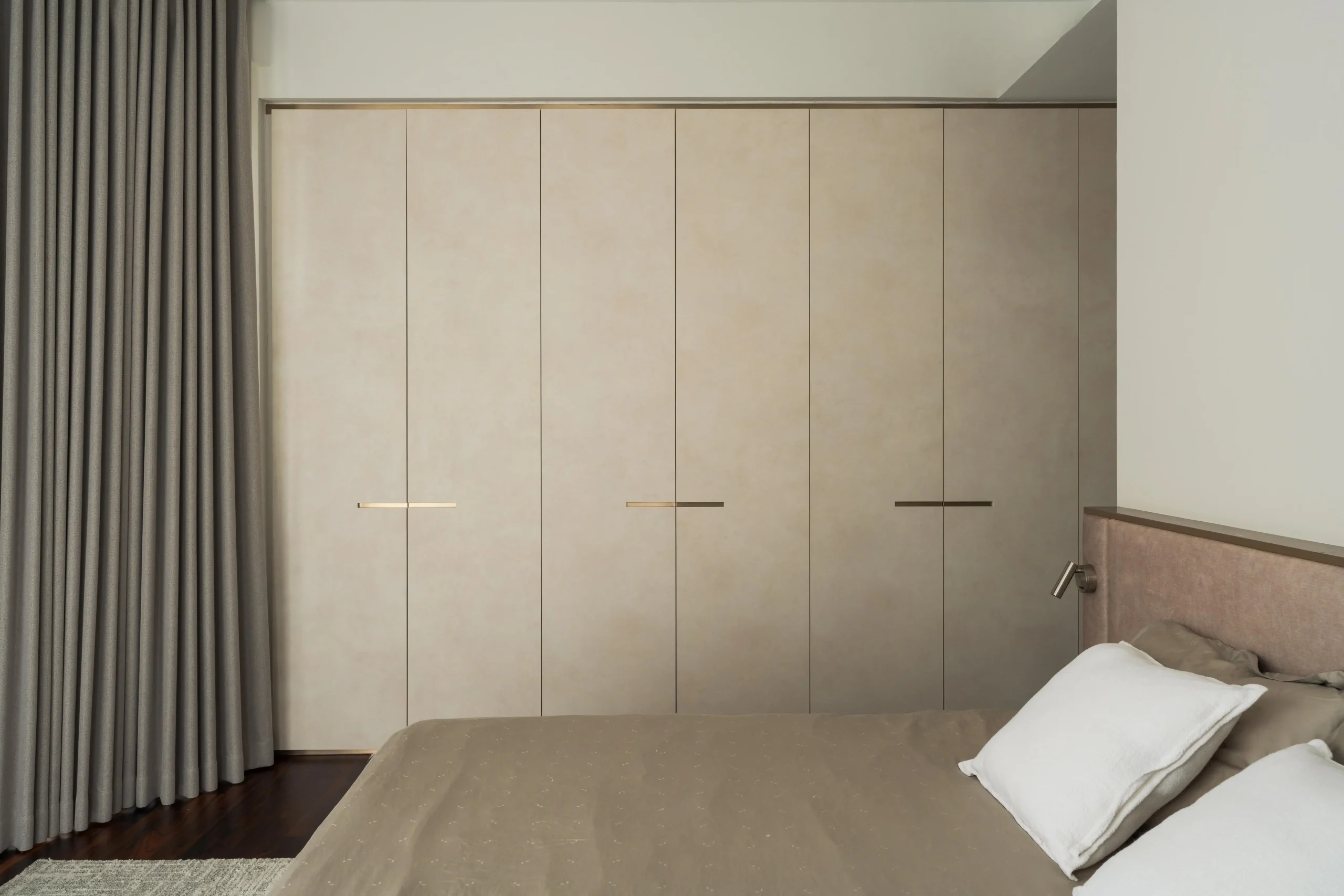 Minimalist bedroom with floor-to-ceiling built-in cabinetry for seamless storage