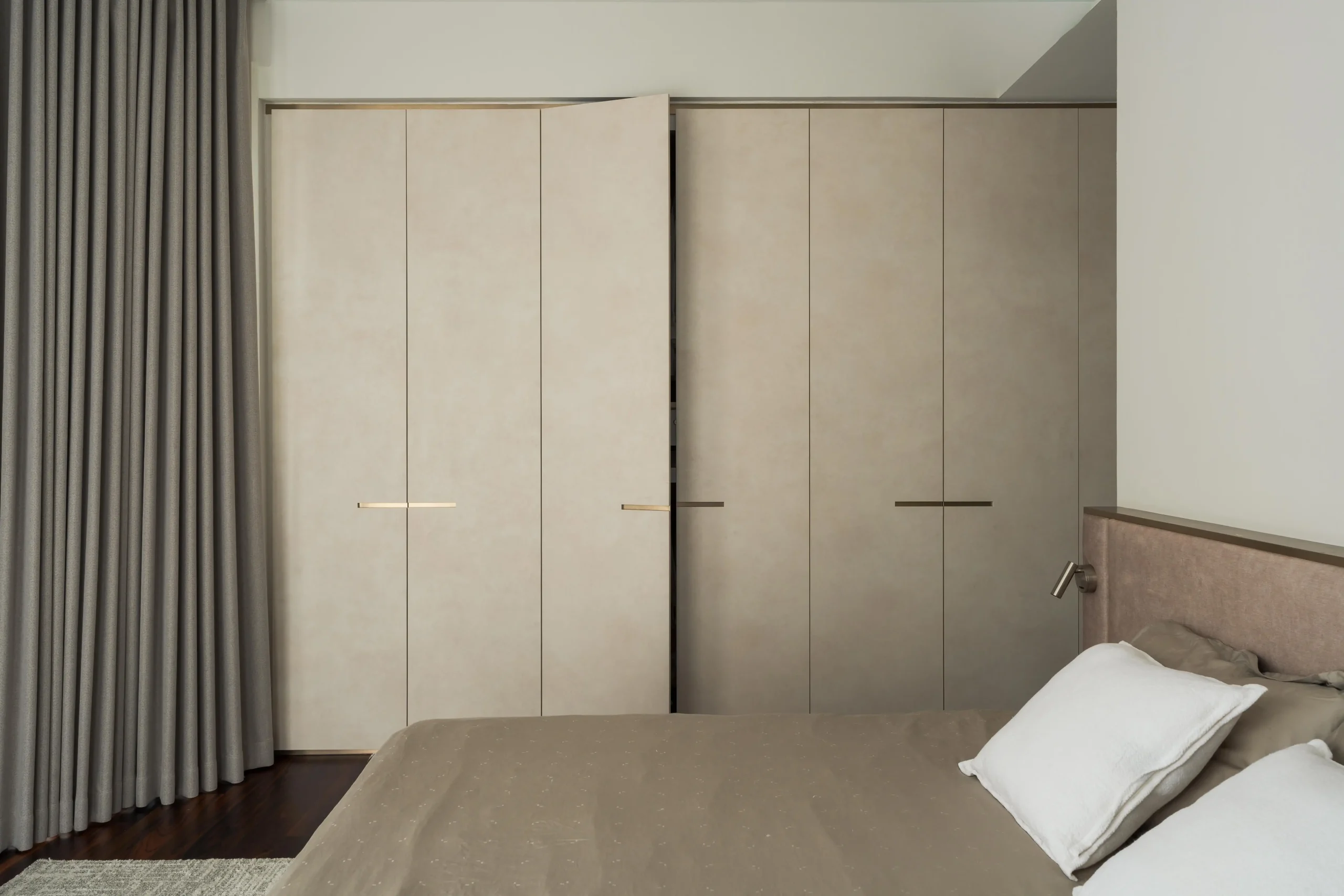 Minimalist bedroom interior with soft neutral tones, clean lines, and uncluttered layout