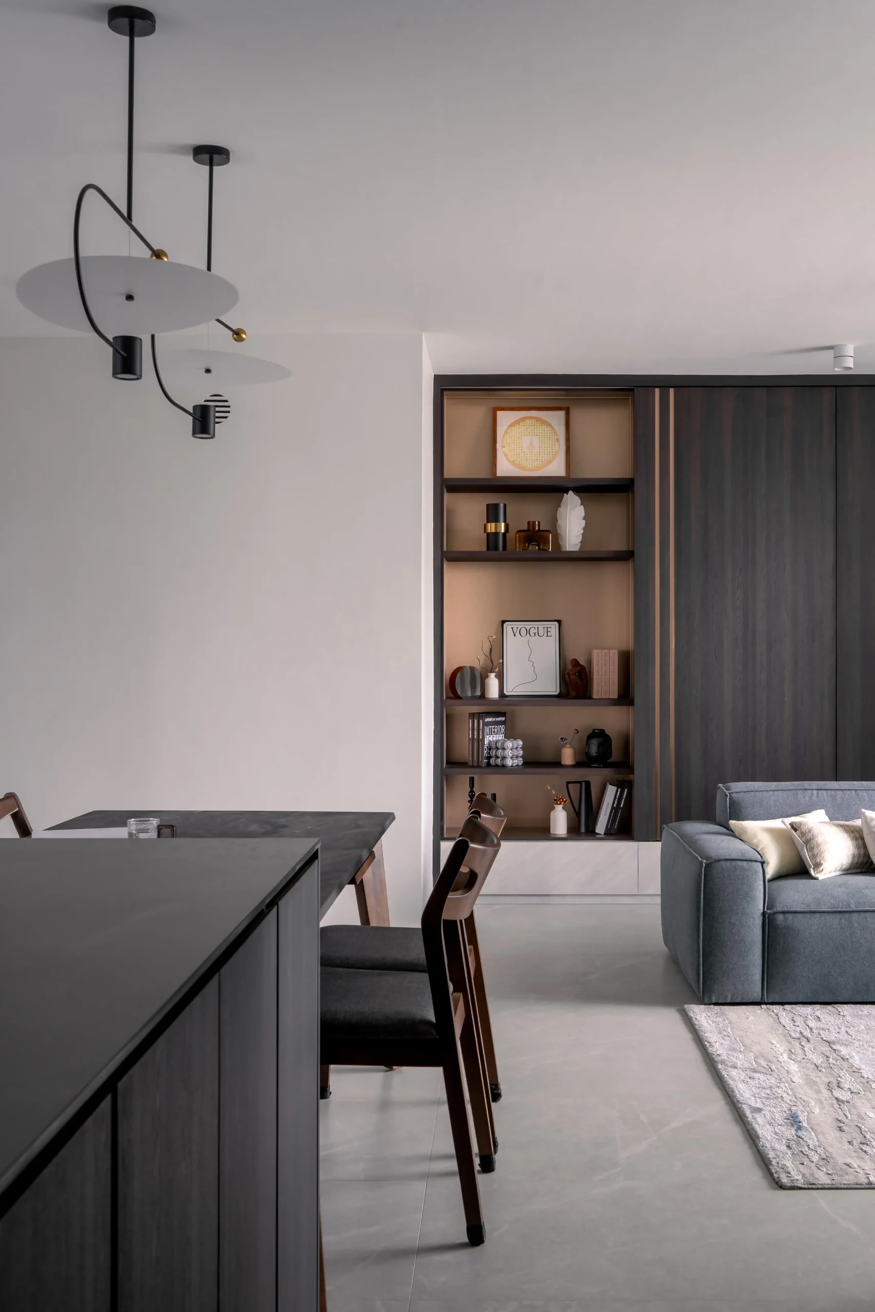 Dining area with sculptural pendant light and built-in shelving in a modern interior design
