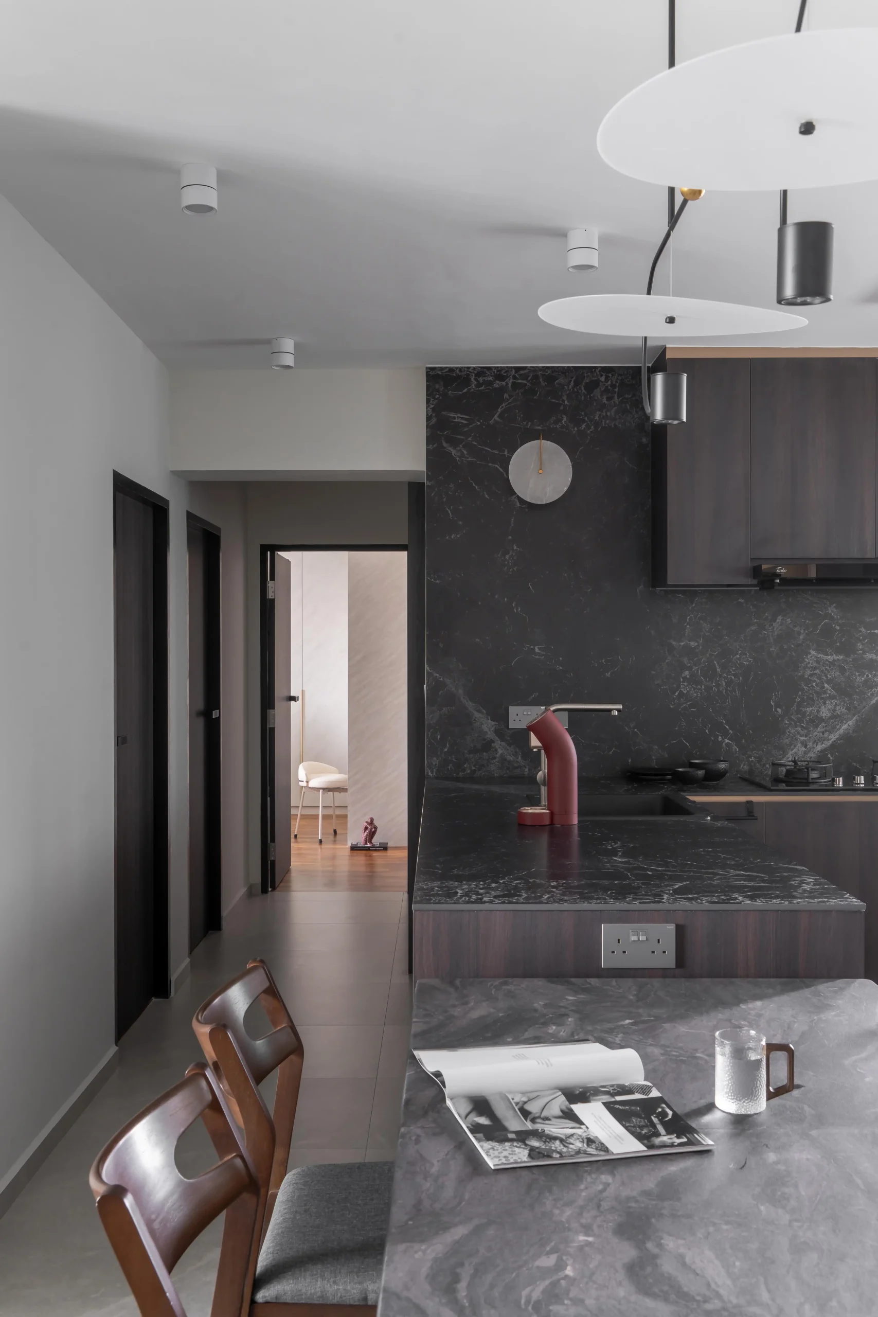 Kitchen with black marble backsplash, dark wood cabinetry, and red espresso machine in a contemporary home interior