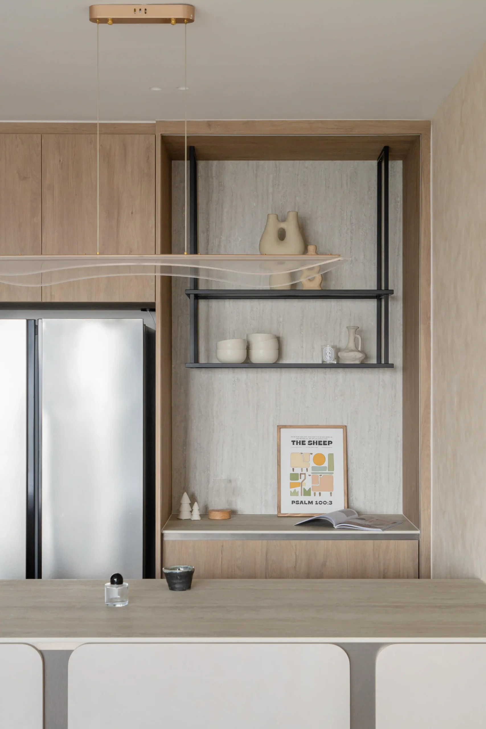 Close-up of a japandi-style kitchen shelf display with handcrafted ceramic pieces, matte black metal frames, and a travertine stone backdrop