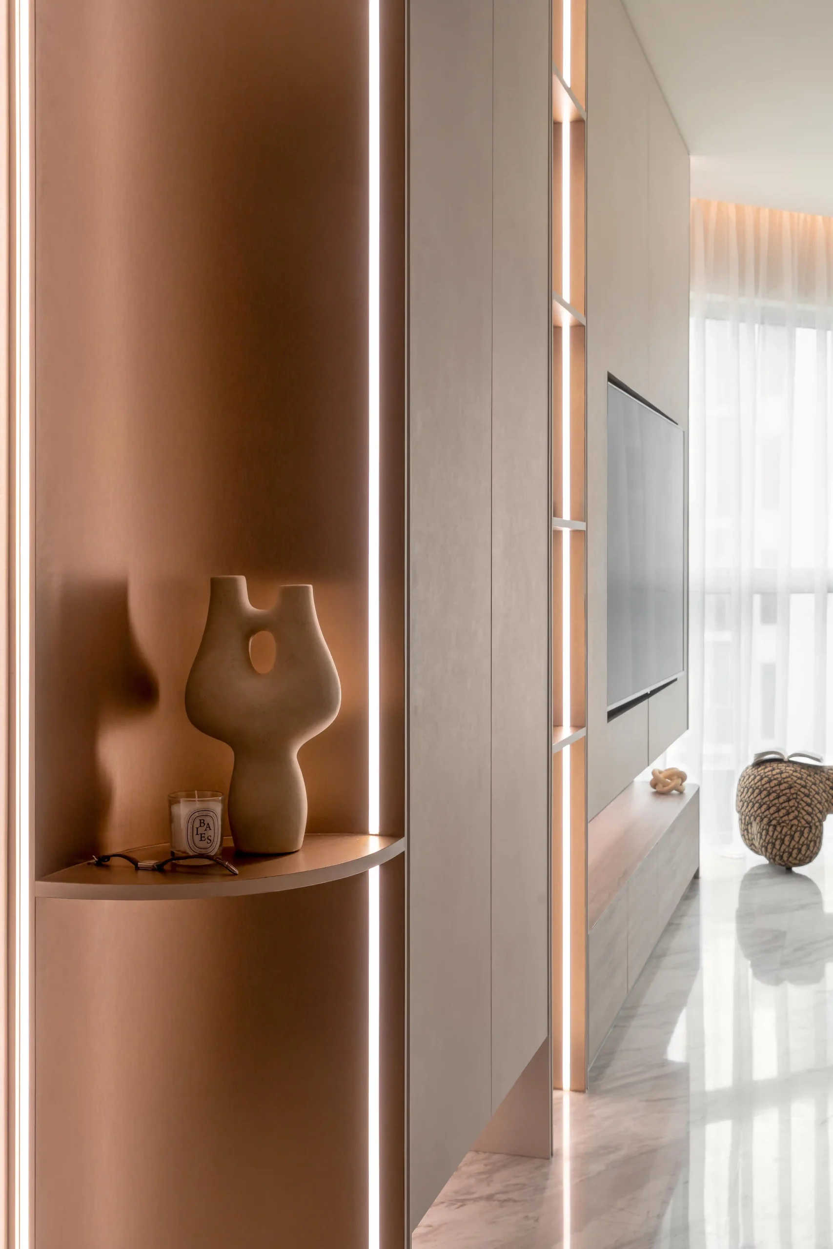 Curved terracotta niche with integrated LED strip lighting and organic ceramic vase display in warm neutral tones