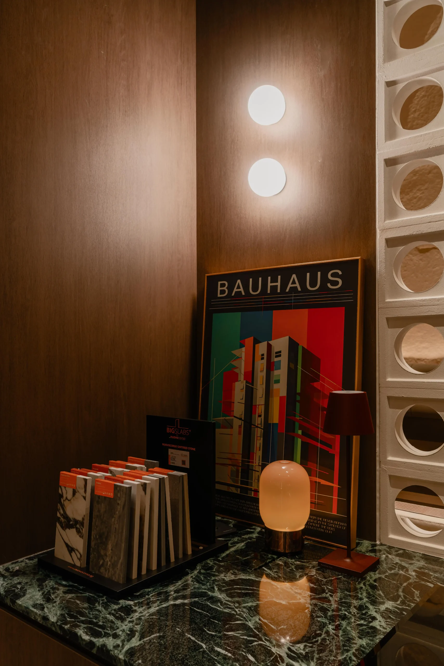 A material inspiration corner with a green marble counter, stacked tile samples.