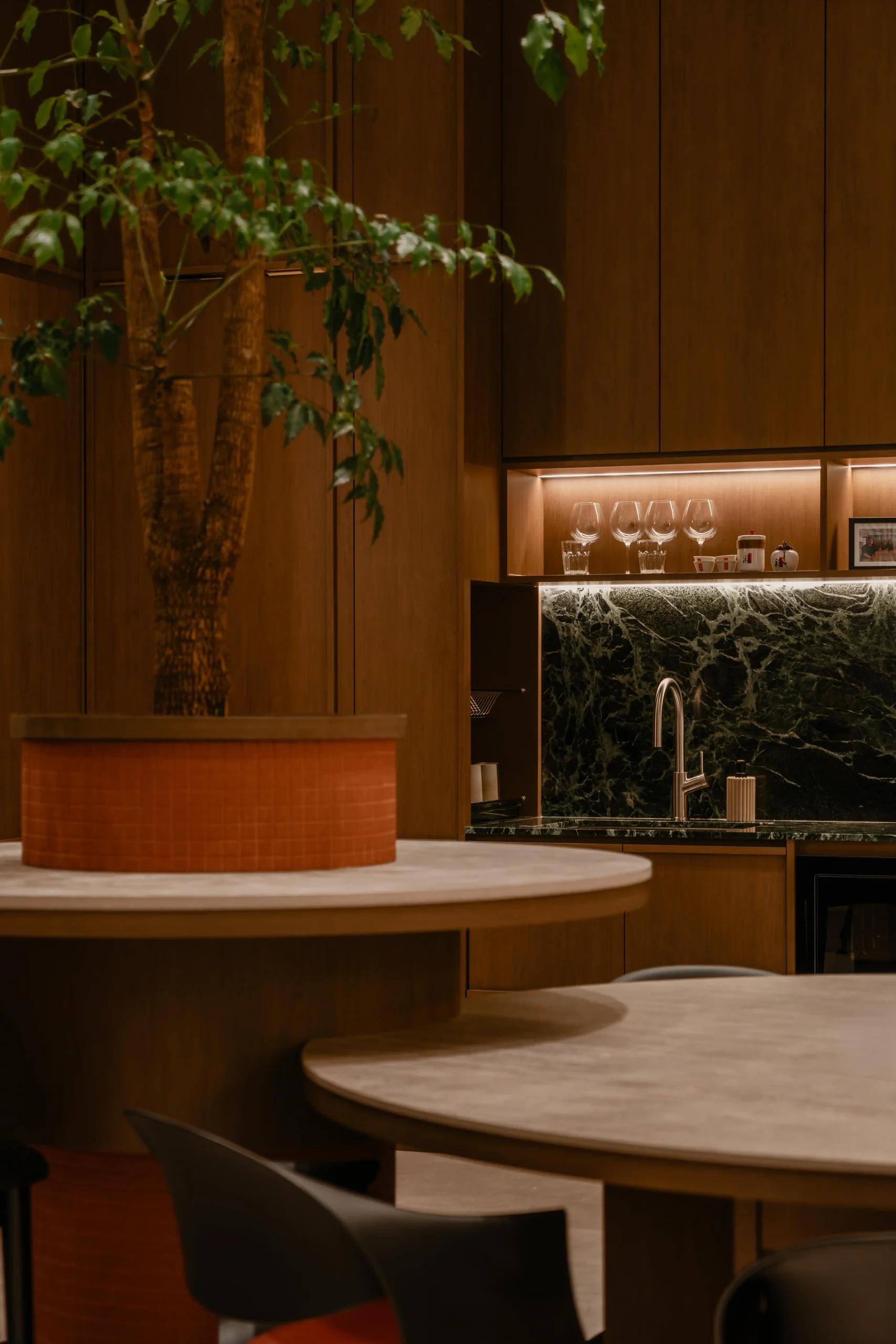 Contemporary office pantry area featuring rich green marble countertops, a sleek faucet, and walnut cabinets