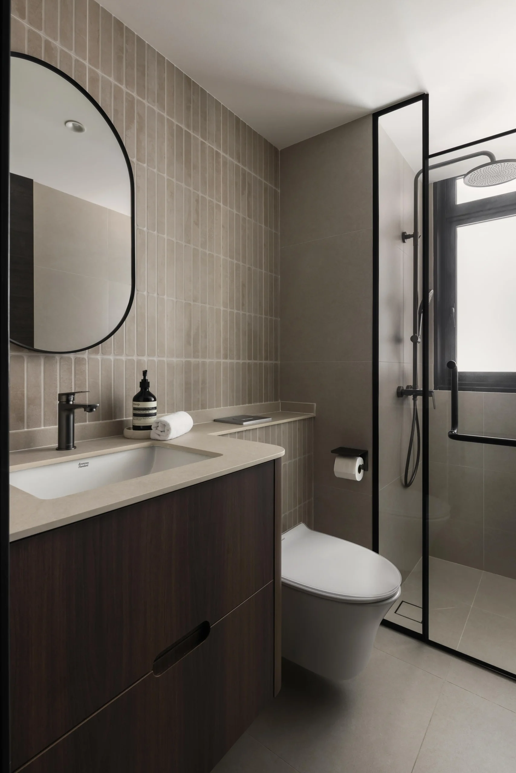 Minimalist bathroom with vertical beige tiles and dark vanity