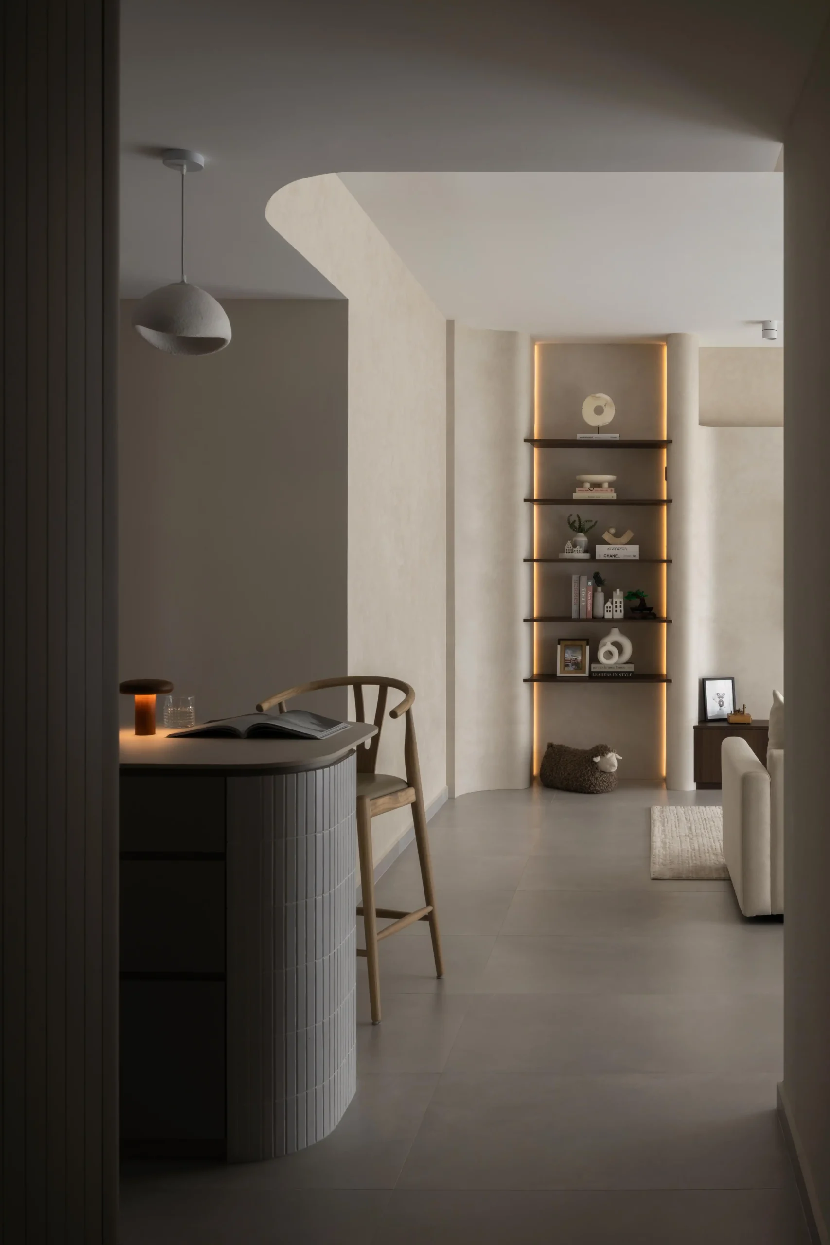 Modern japandi kitchen with a curved ribbed island and warm backlit shelves