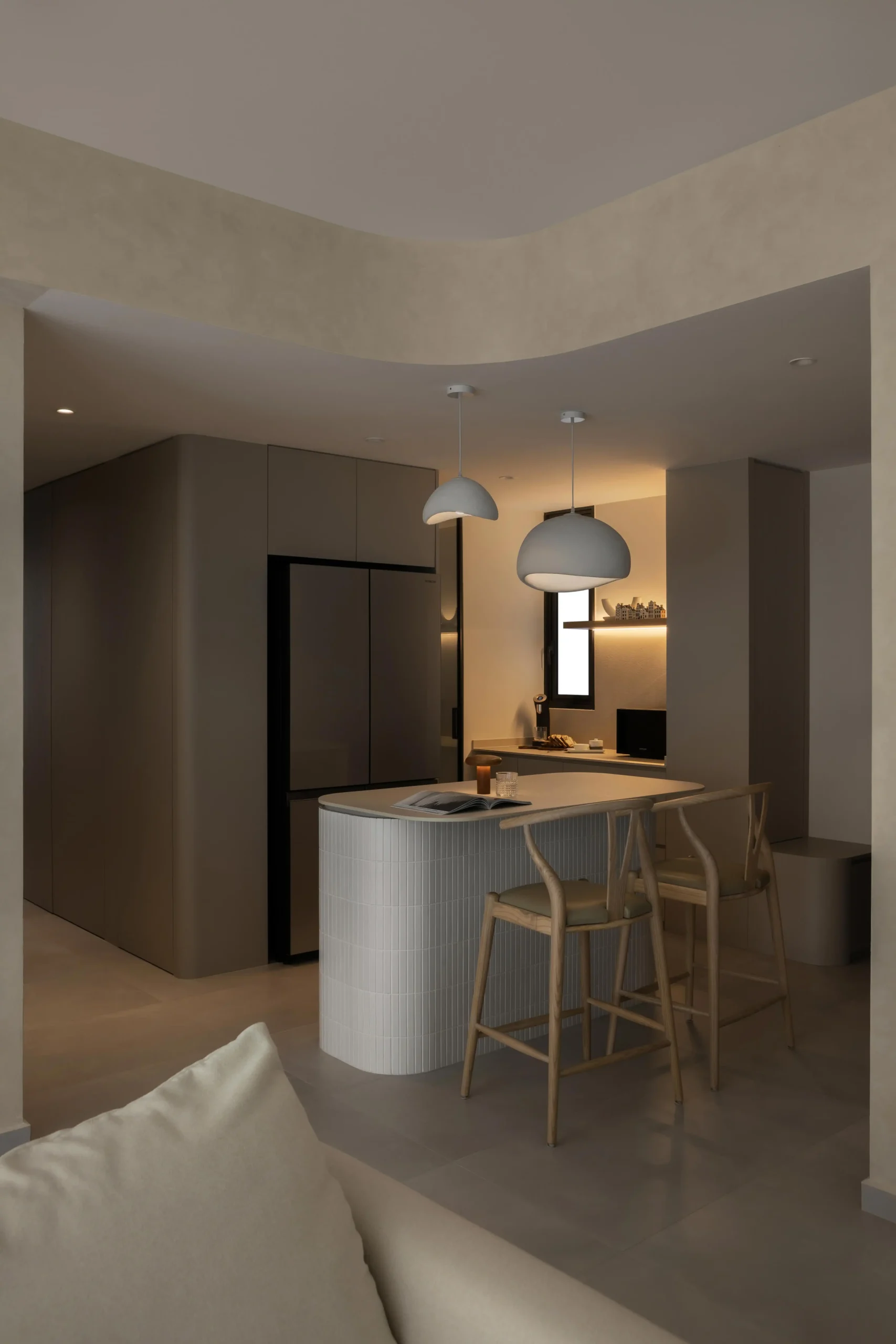 Textured curved kitchen island with wooden bar stools in modern japandi style.